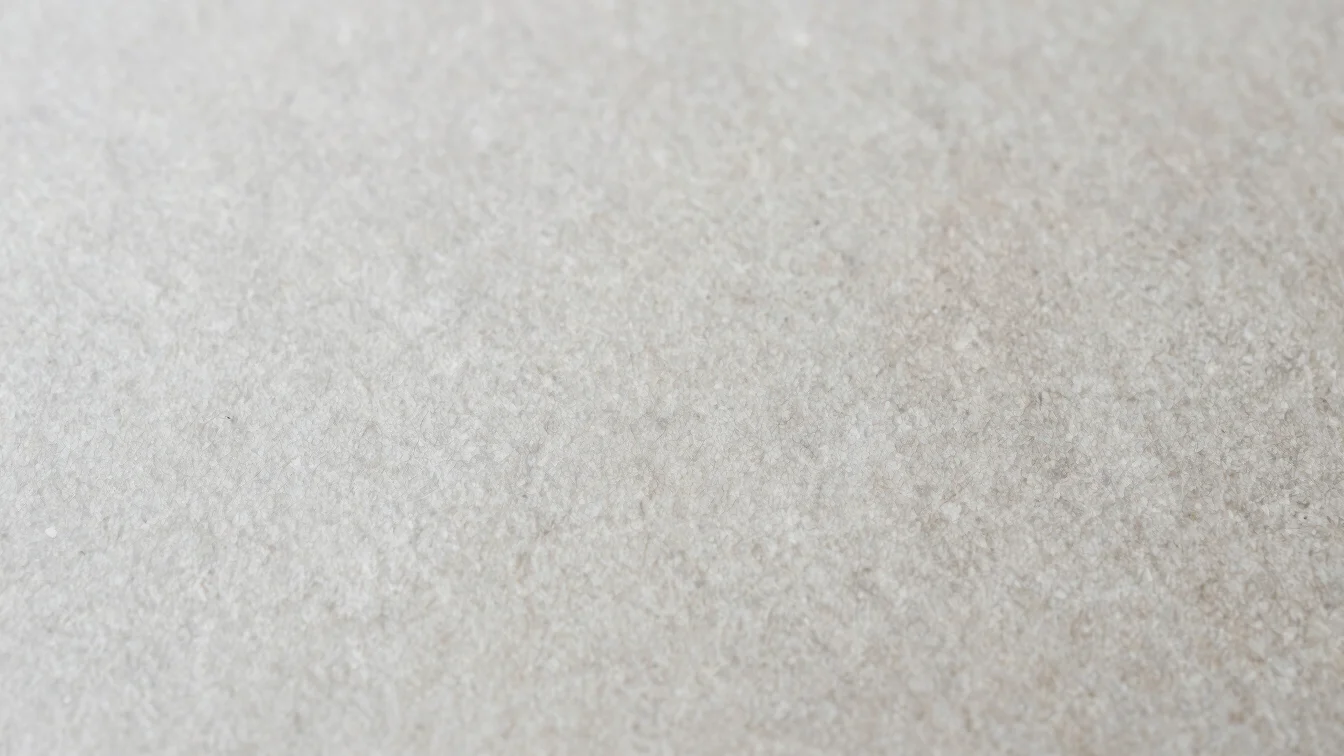 Close-up of natural material textures, raw paper, wood and stone surfaces, soft daylight, muted neutral tones, 50mm lens